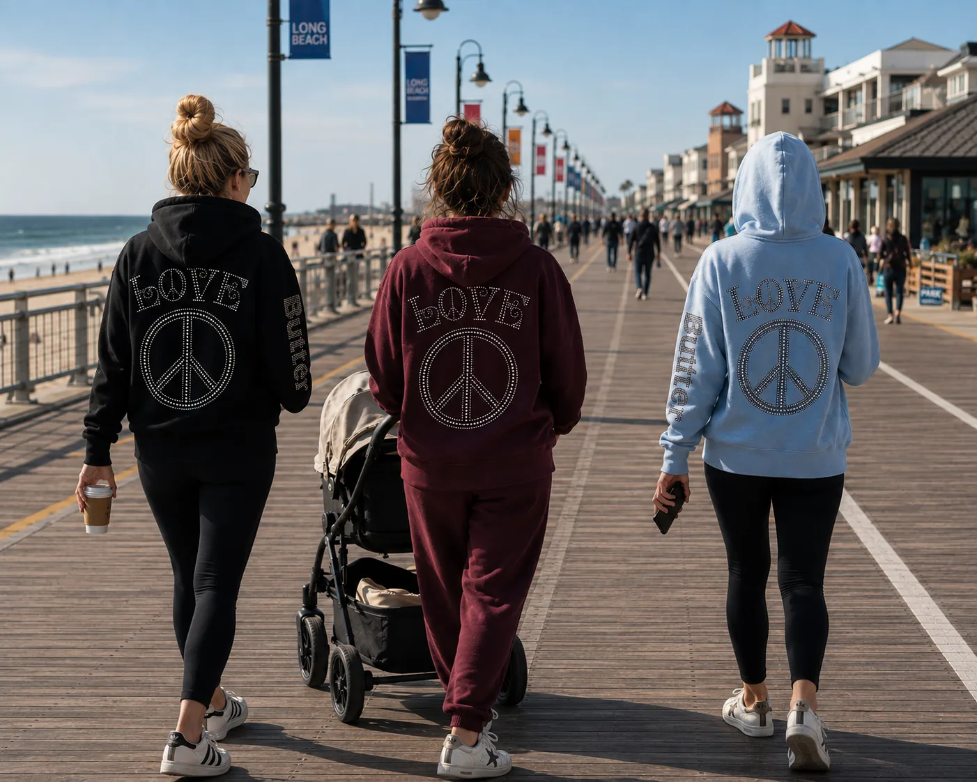 Three people wearing Butter hoodies while walking on a boardwalk