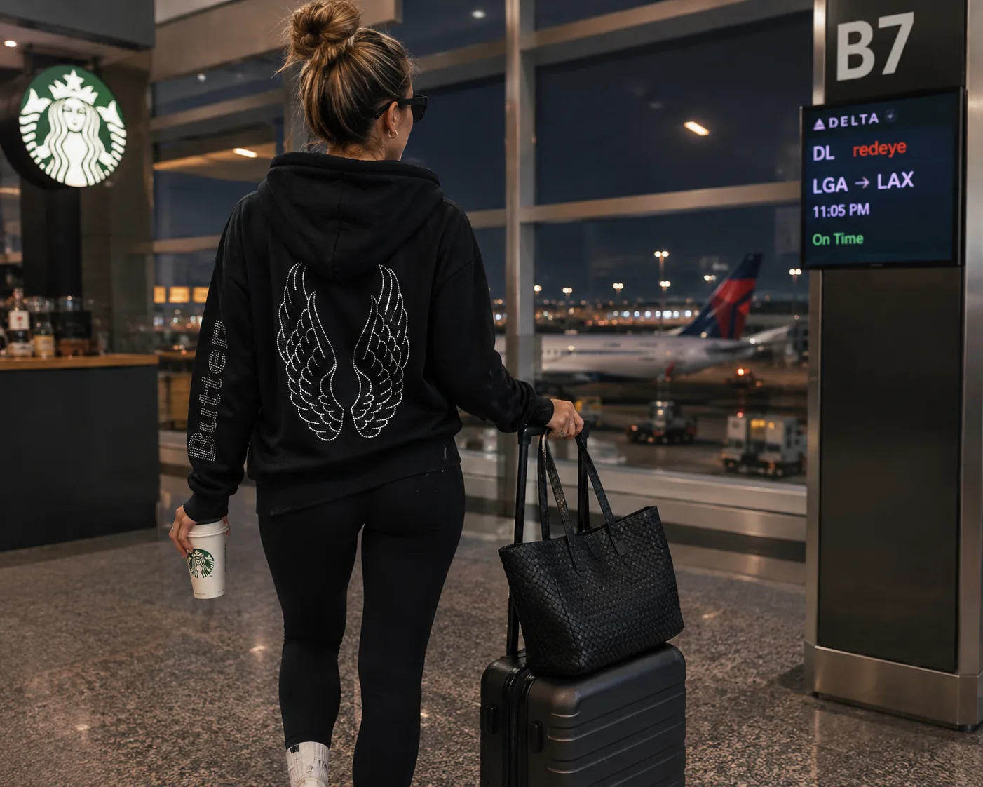 Person wearing a black Butter hoodie with a wing design