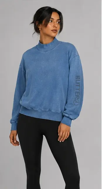 Model wearing a blue mock neck sweatshirt with burnout texture and 'BUTTER' text on the left sleeve.