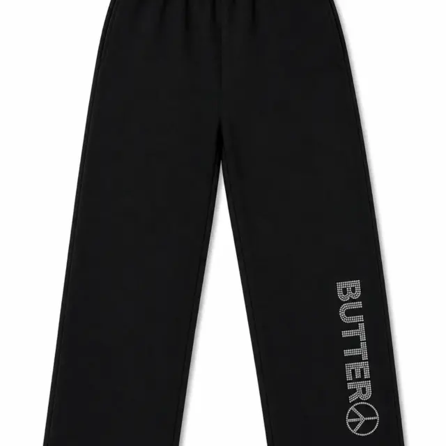 Black wide-leg sweatpants shown in a flat lay. A rhinestone 'BUTTER' logo with a peace sign is visible on the lower left leg.