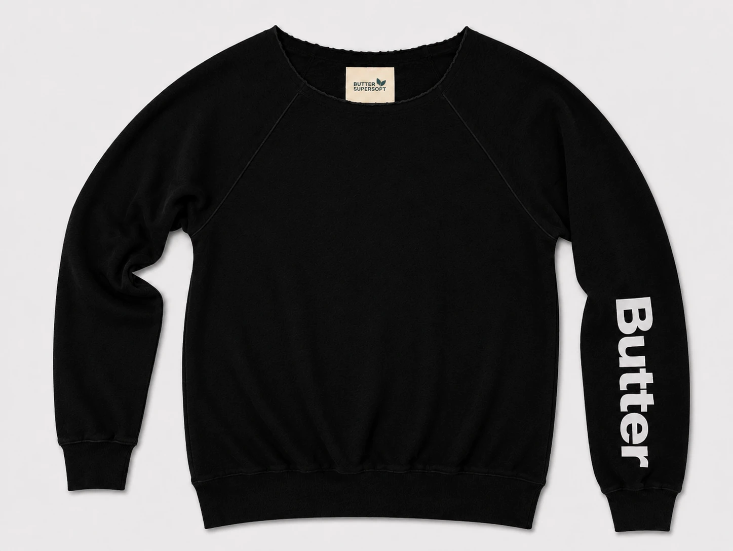 Flat lay of a black off-the-shoulder sweatshirt featuring white 'Butter' text on the left sleeve and a 'Butter Super Soft' neck tag.