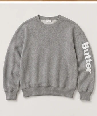 Heather grey crewneck sweatshirt with ribbed trim and 'Butter' printed on the sleeve.