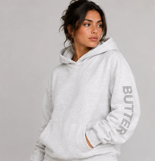 Model wearing the Ash Butter Plush Diamond Oversized Hoodie with rhinestone sleeve lettering.