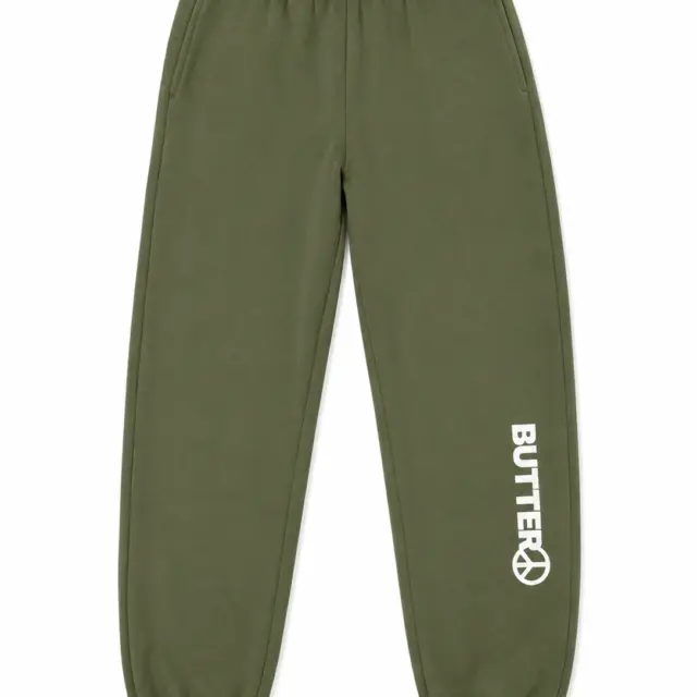 Olive green sweatpants with a white vertical logo and peace sign graphic on the lower left leg, featuring an elastic waistband and elasticated cuffs.