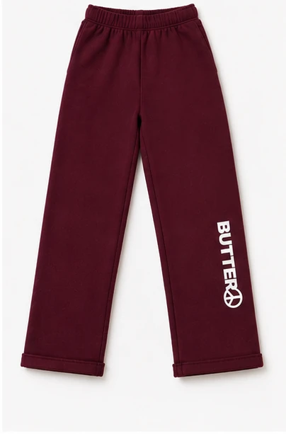Flat lay of dark burgundy wide-leg sweatpants with 'Butter' and a peace sign logo printed vertically on the lower leg.